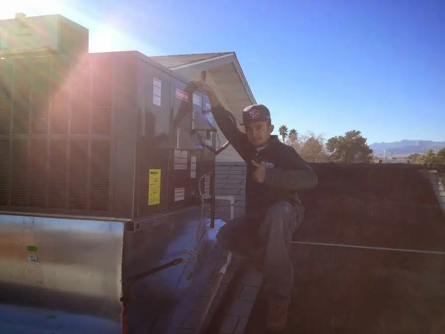 HVAC technician performing Air Duct Cleaning on a rooftop unit in Northbrook